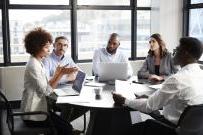 Divers group of five adults sitting around a conference table